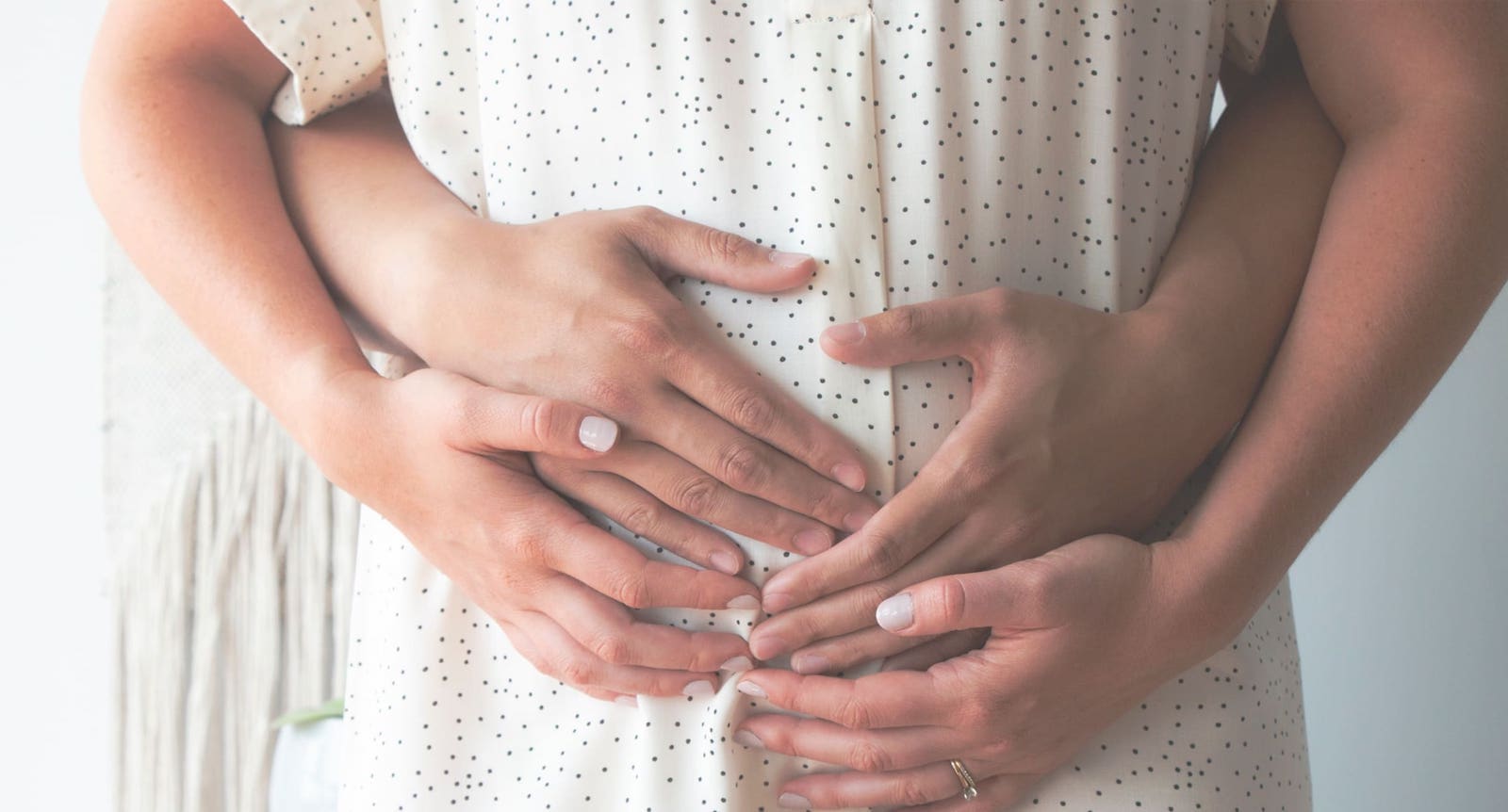 Hands on a pregnant woman's stomach