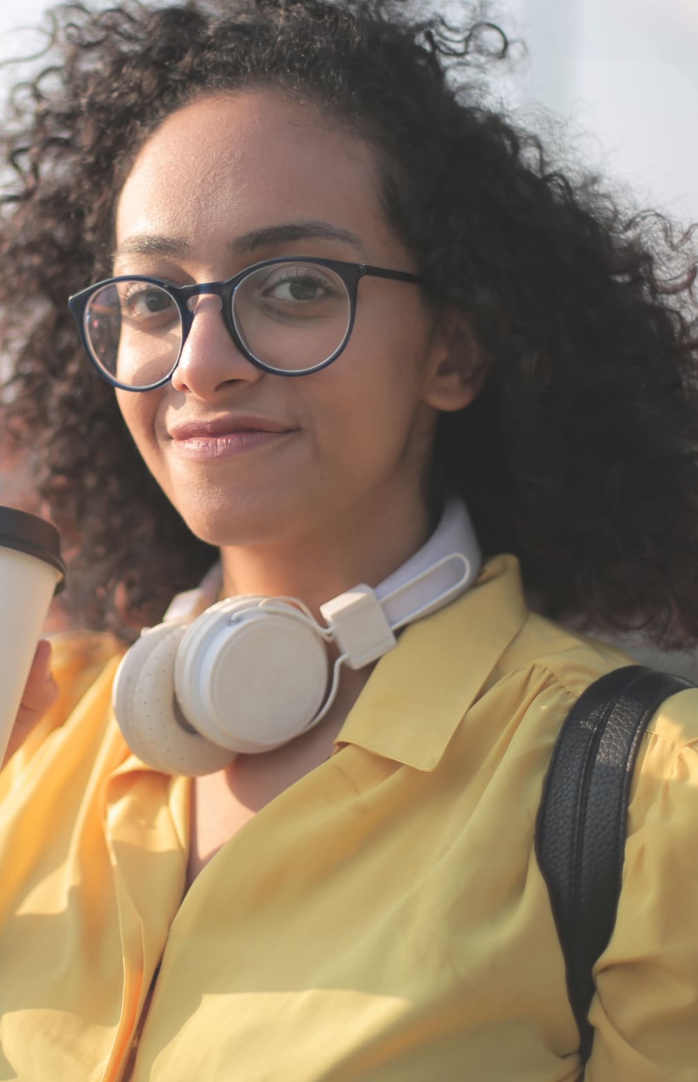 Woman wearing glasses and headphones around her neck