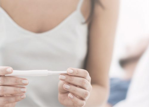 Woman with infertility issues holding a pregnancy test