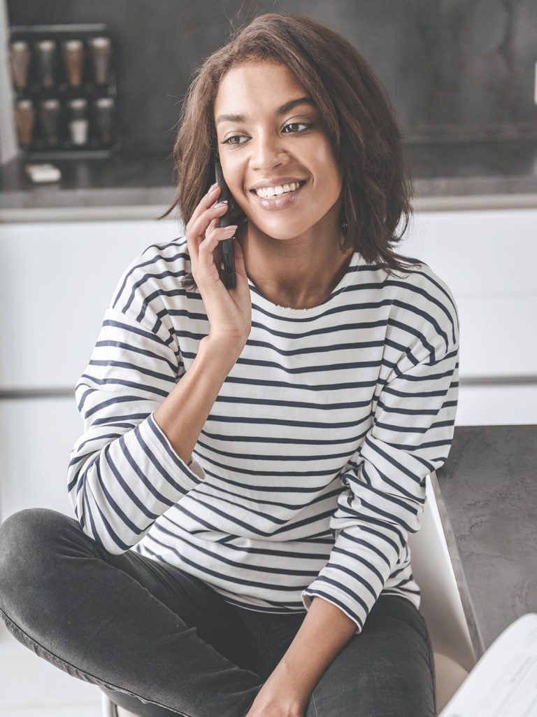 Woman wearing a striped shirt, talking on her cell phone