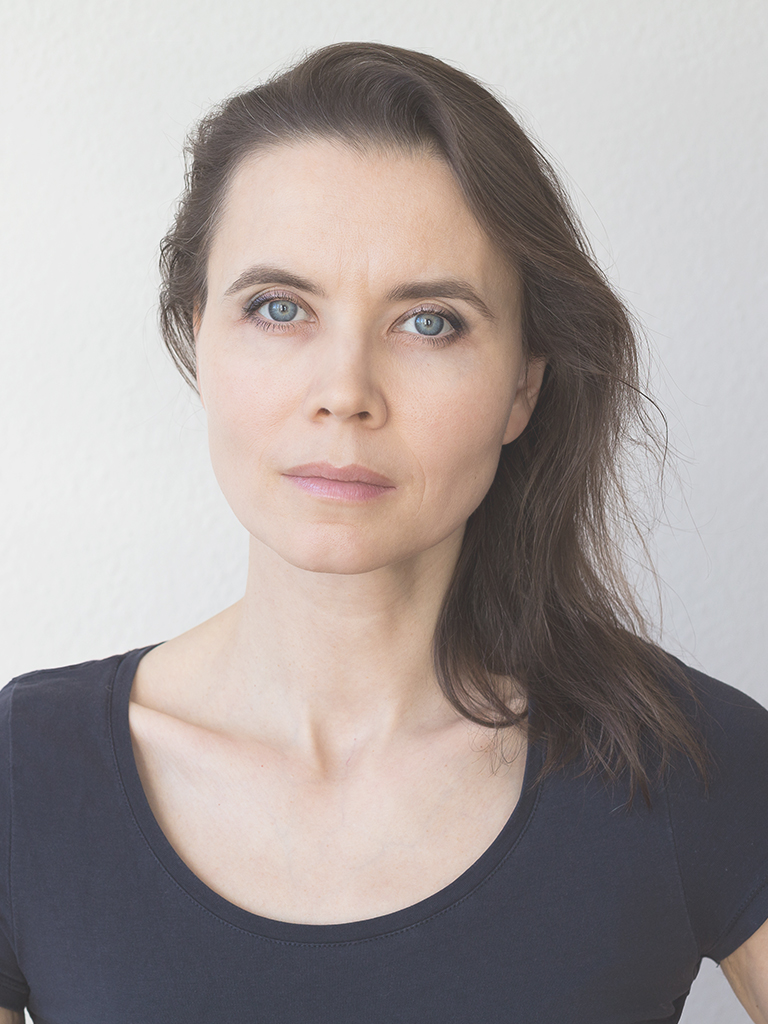 Portrait photo of a woman with brown hair and blue eyes